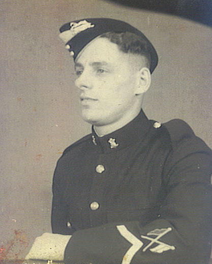 A studio portrait of a young soldier in dress uniform and cap.